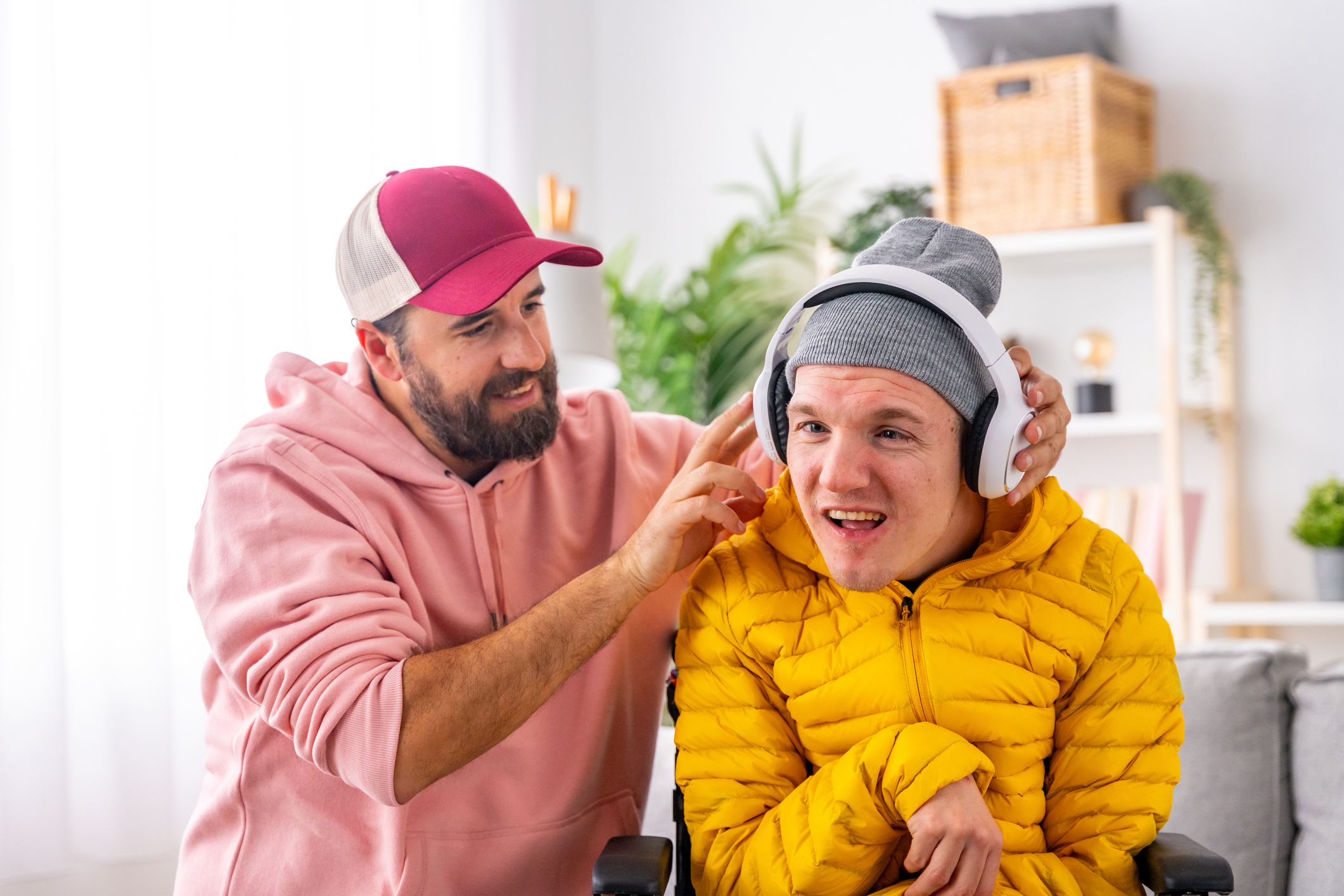Disabled man using headphones listening to music with friend
